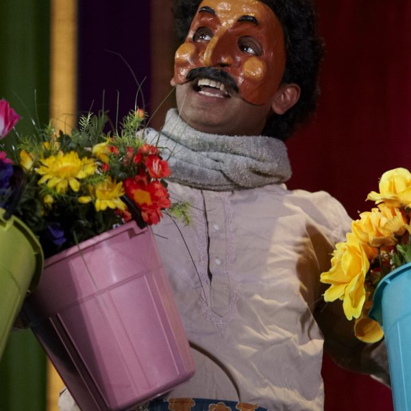 Gobi Krishnan holds colourful buckets of flowers.
