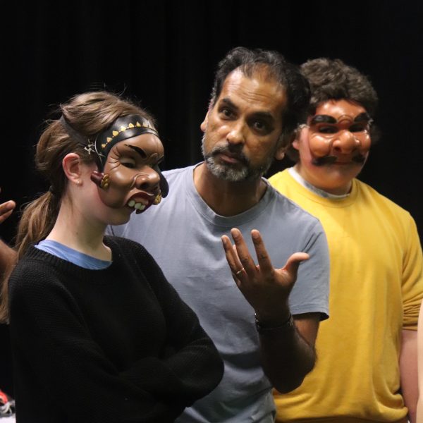 Jacob teaches two students wearing Indian Ink masks at a workshop.