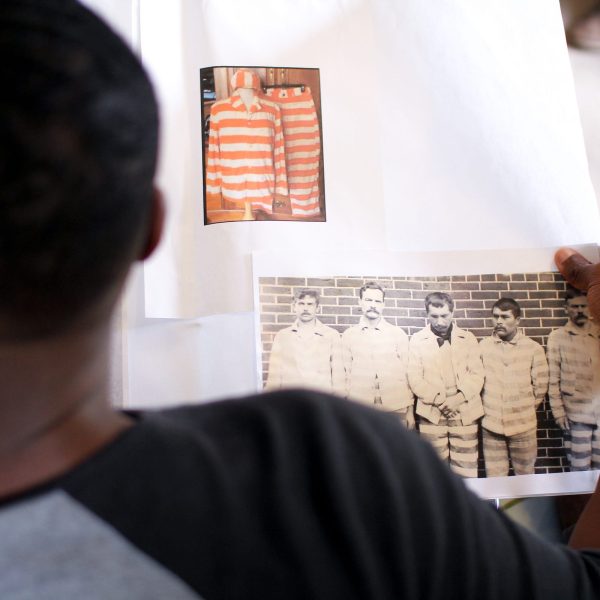 Performer Quentin Warren examines the proposed designs for the show’s choir, made of death-row inmates.