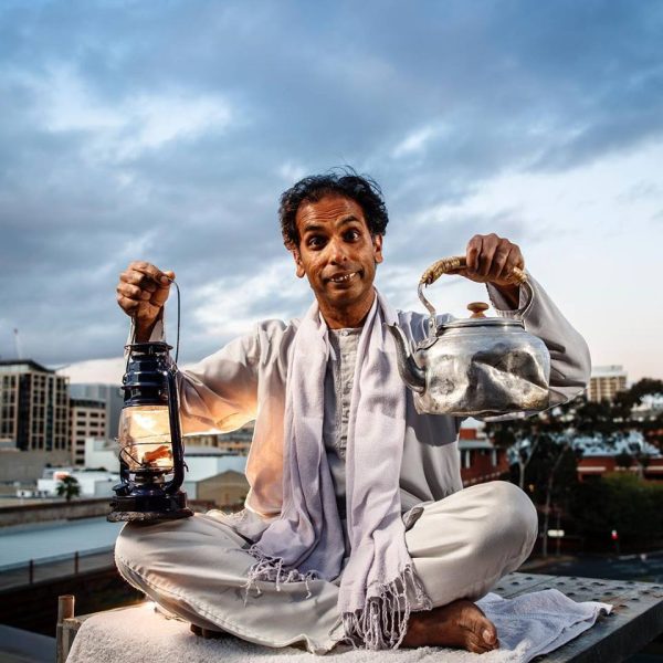 Actor Jacob Rajan as Kutisar from Guru of Chai on a roof, holding a lantern and a tea pot