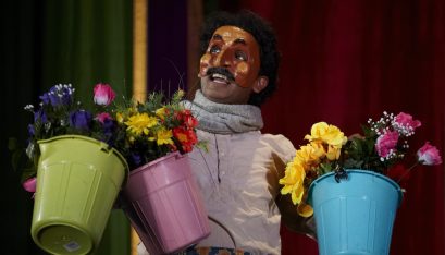Jacob Rajan as Gobi in Krishnan’s Dairy holding 3 buckets of flowers