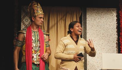 Actors Justin Rogers and Kalyani Nagarajan as DJ Jimmy J and Mrs Krishnan stand greeting the audience