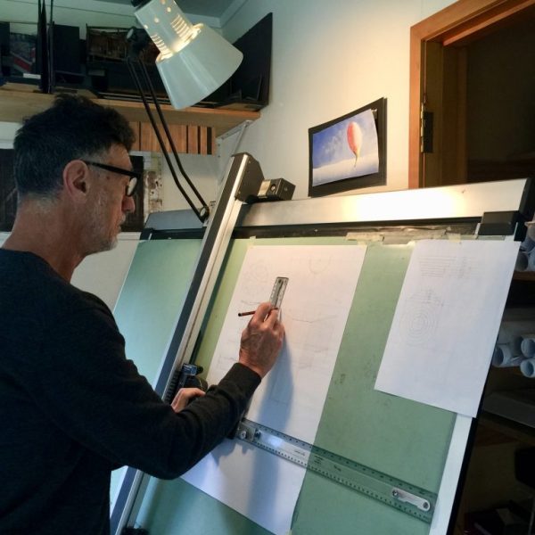John Verryt sits in front of his drawing board. 
