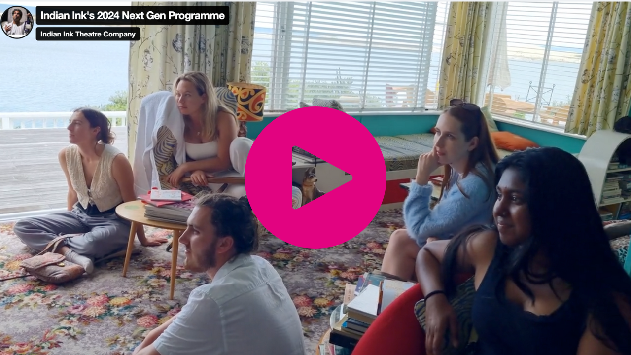 Image of 4 females and 1 male sitting in a 70's style room looking to the left of the camera. There is a large pink play button in the middle of the image which directs you to Indian Ink's Next Gen programme video. 