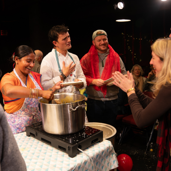 Kalyani serves dlah after the show while Justin takes to a patron and Andrew helps serve