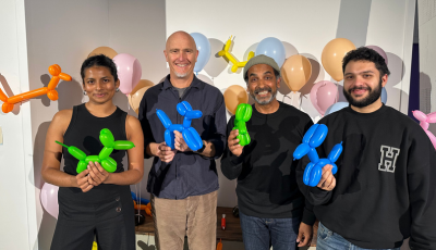 Cast stand holding Balloon Dogs smiling at the camera